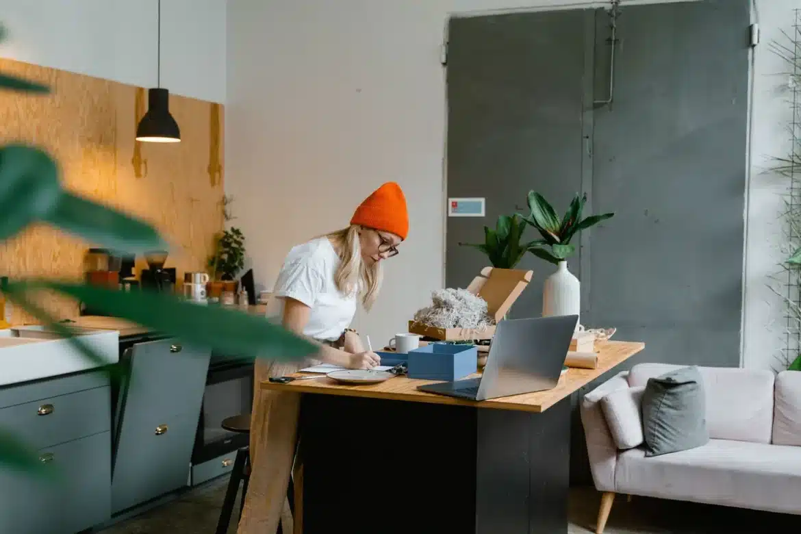 Espace de travail montrant des étiquettes d'expédition, de l'argent canadien et des colis préparés pour l'envoi