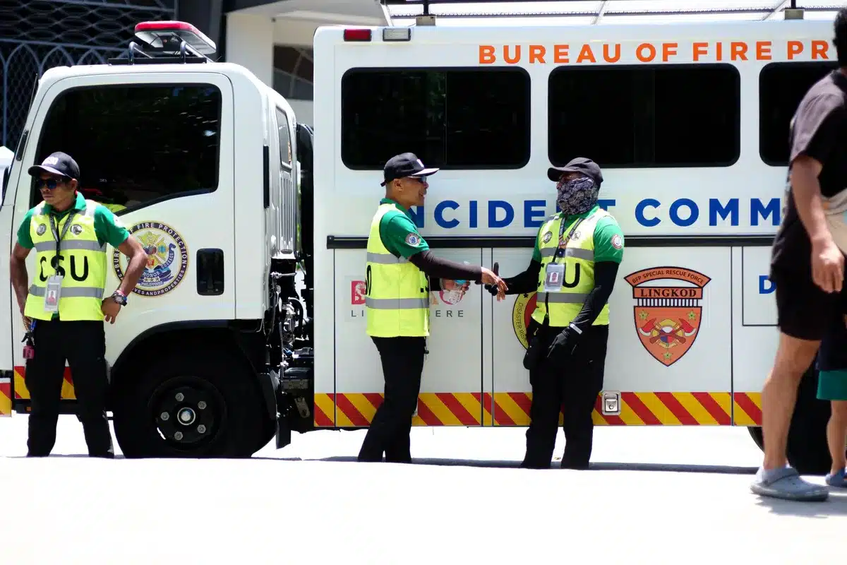 Équipe en réunion d'urgence autour d'une table avec ordinateurs portables, discutant d'une situation de crise