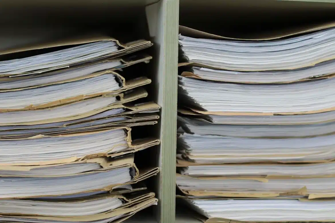 Mains tenant les clés d'une voiture et des documents administratifs sur un bureau