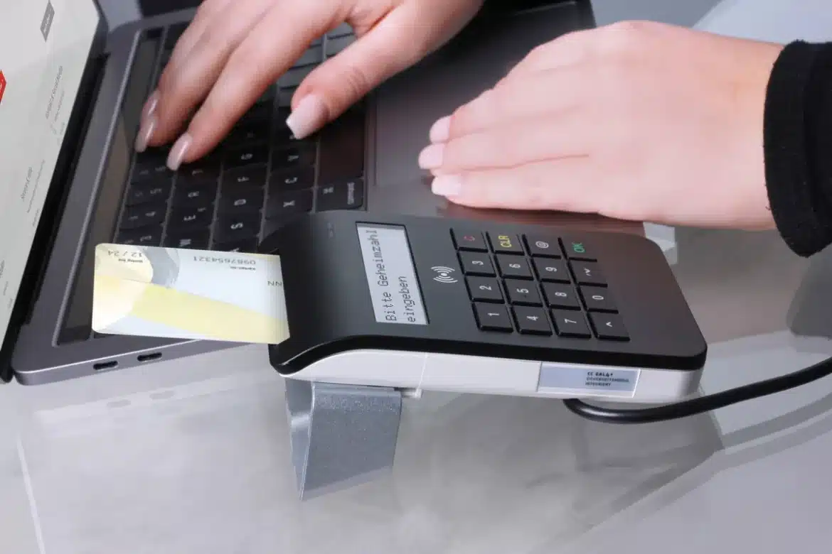Mains d'un vendeur consultant le tableau de bord des paiements eBay sur un ordinateur portable