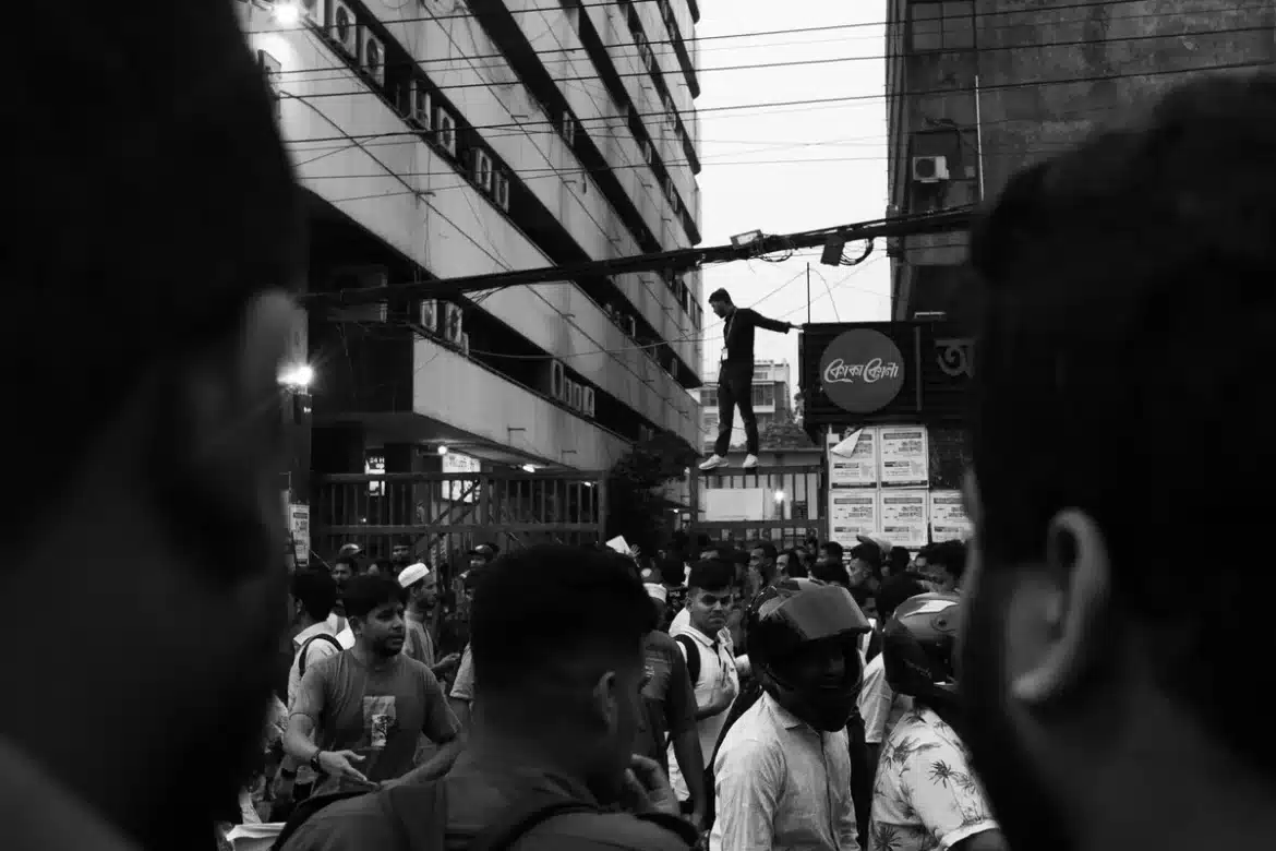 Personne isolée dans un espace public bondé, entourée de silhouettes floues, affichant une attitude tendue et repliée su