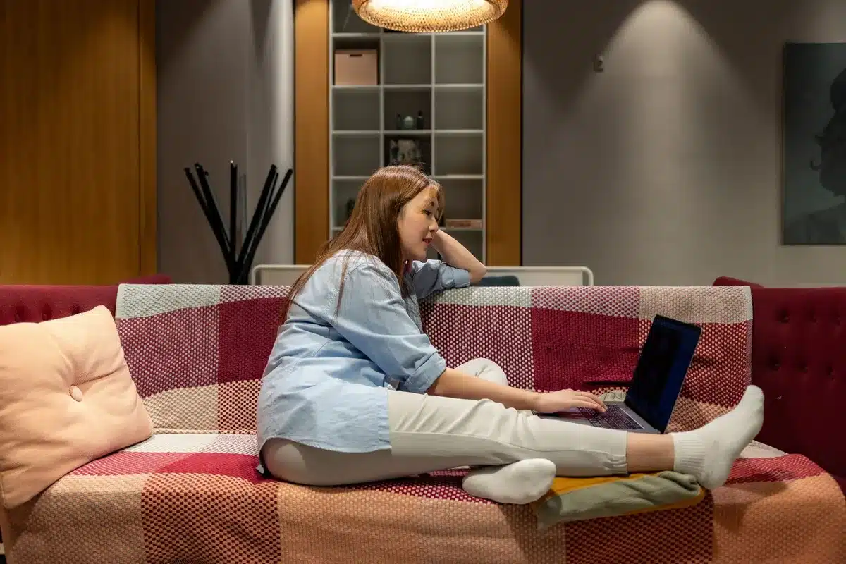 Personne travaillant sur ordinateur portable à domicile, illustrant le télétravail comme aménagement.