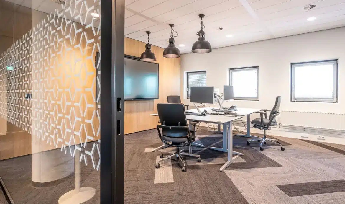 Salle de réunion d'entreprise vide avec table ronde et chaises, lumière naturelle douce.