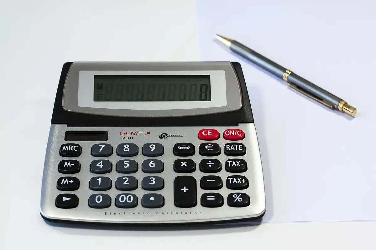 Calculatrice et fiches de paie posées côte à côte