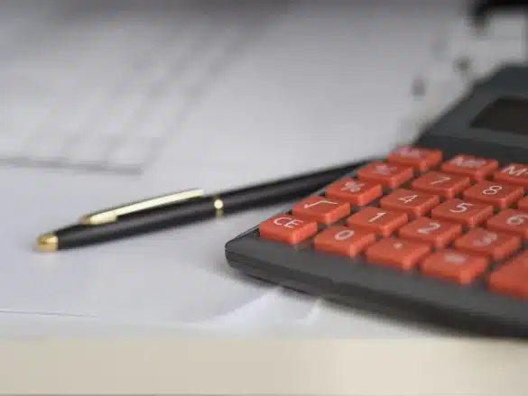 Bureau en plein jour avec feuille de présence et calculatrice sur une table