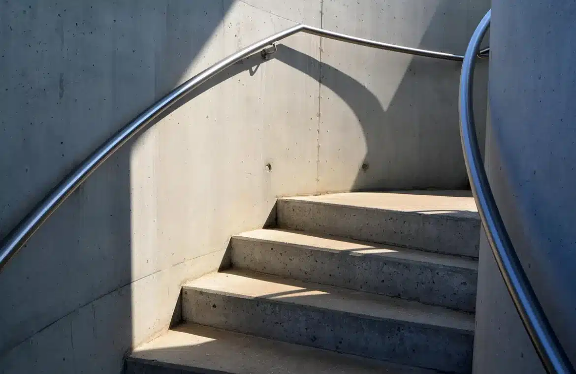 Contrat de travail, casque de chantier et tablette posés sur un bureau baigné de lumière