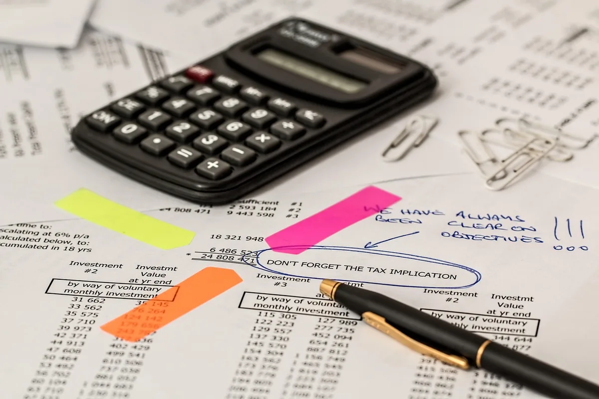 Calculatrice et factures sur un bureau pour illustrer les coûts e‑commerce