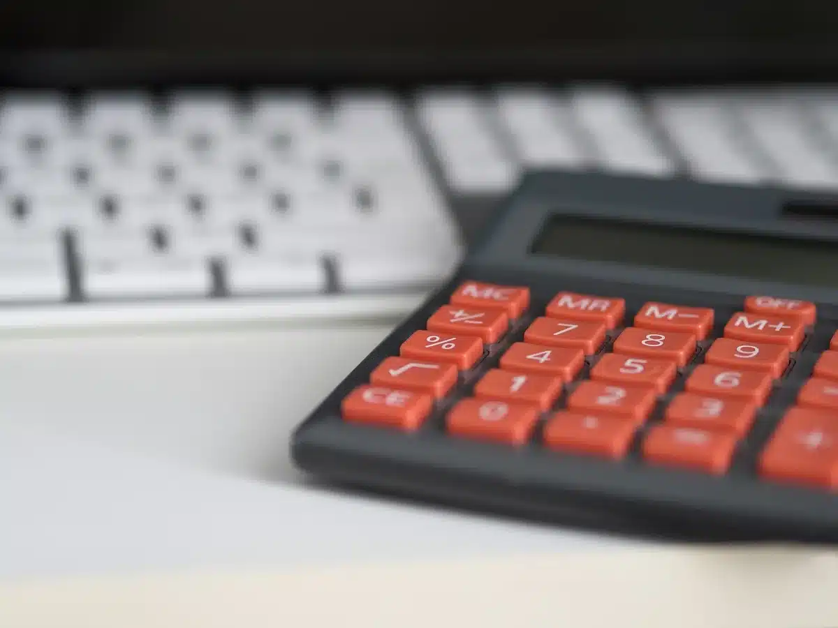 Calculatrice et documents financiers sur un bureau, illustrant l'absence d'investissement en stock