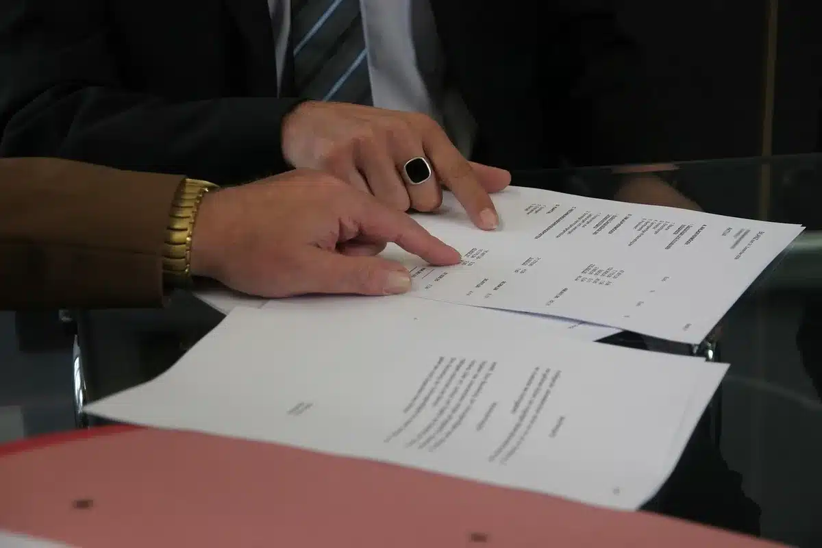 Mains sur un contrat de travail posé sur une table de bureau