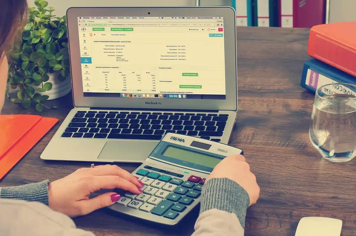 Calendrier annuel 2026 posé sur un bureau avec calculatrice pour le calcul des jours RTT