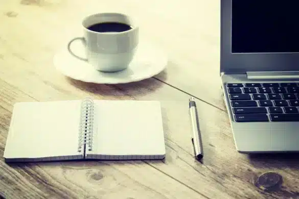 Bureau en journée avec un ordinateur affichant un tableau de bord e‑commerce et notes d'expédition