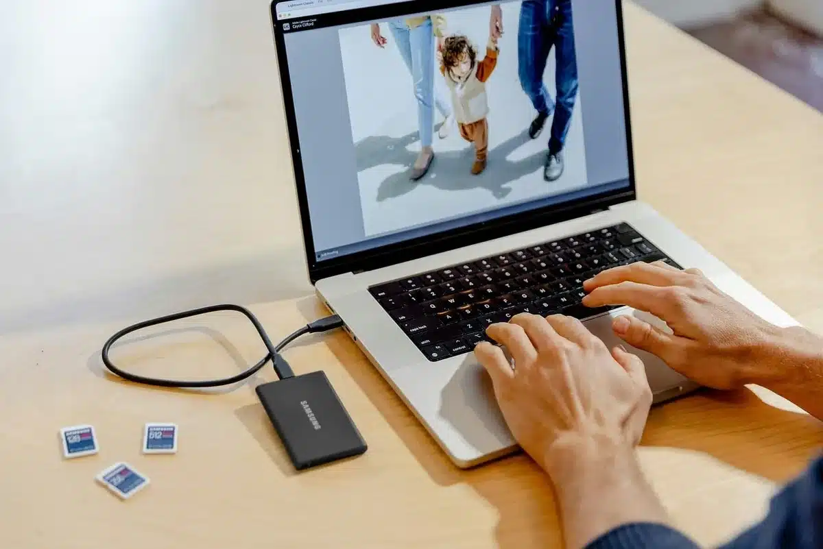 Main ajustant des photos produit sur un ordinateur portable