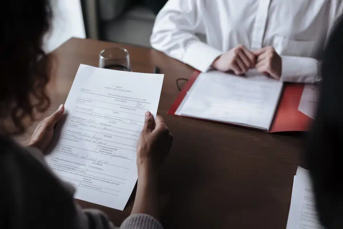 Contrat de travail posé sur un bureau avec stylo et ordinateur